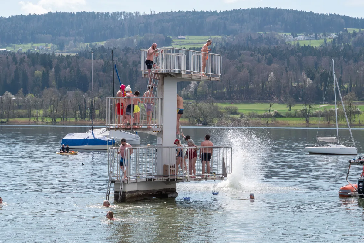 Auf dem Sprungturm im Greifensee holen sich die Teilnehmenden ihre blauen Eier. Blaueierschwimmen 2026